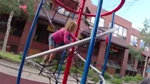 WINTER PARK COLORADO-2019: Girl At The Playground With Her Dad Climbing Up Some Equipment