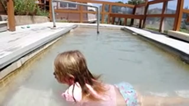 WINTER PARK COLORADO-2019: Little Blond Girl Smiling In A Small House Pool In A
