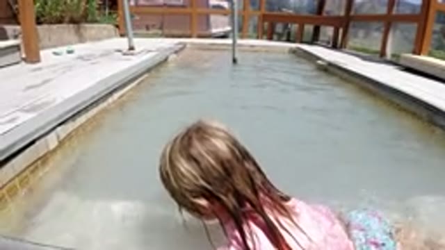 WINTER PARK COLORADO-2019: Little Girl Playing on the Pool Step on a Summer Day