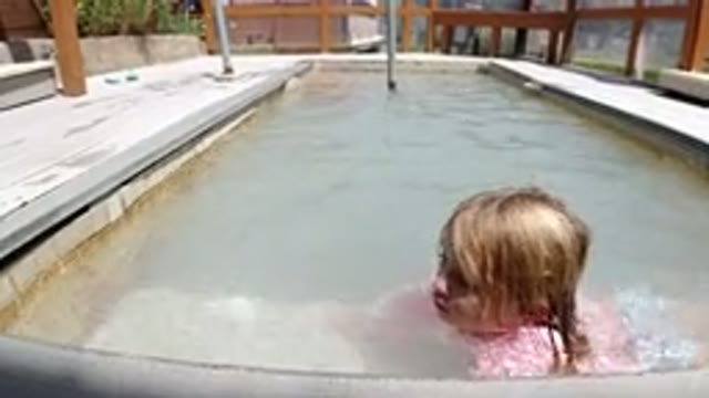 WINTER PARK COLORADO-2019: One Girl Playing by Swimming Pool and Wood Wall