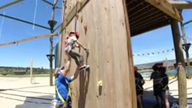 WINTER PARK COLORADO-2019: Little Girl Climbing Wall At Amusement Park
