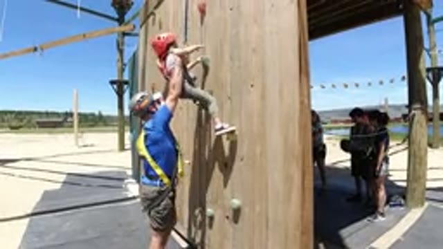 WINTER PARK COLORADO-2019: Child Climbing Wooden Wall with Man's Assistance