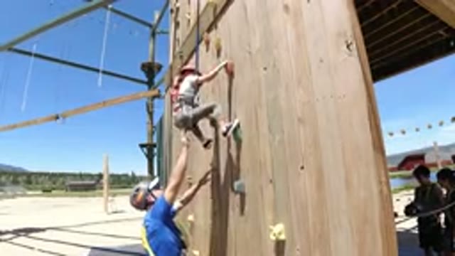 WINTER PARK COLORADO-2019: A Boy Tries To Climb A Climbing Wall Helped By An Adult