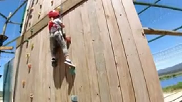 WINTER PARK COLORADO-2019: Small Child Is Harnessed And Climbing Up A High Rock Wall