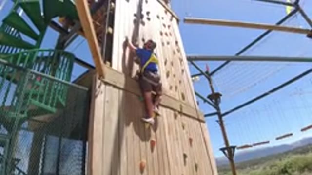 WINTER PARK COLORADO-2019: A Man Wearing A Harness And Helmet Climbs An Artificial Cliff Wall