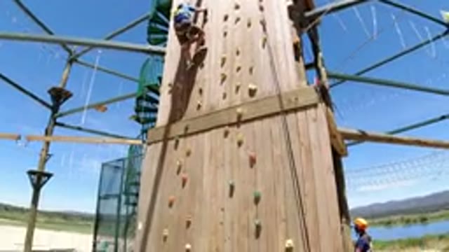 WINTER PARK COLORADO-2019: A Man Climbs Down A Wooden Climbing Wall On A Nice Day