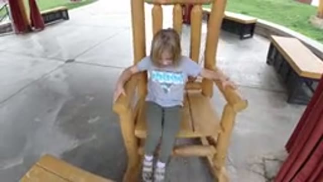 WINTER PARK COLORADO-2019: A Little Girl Rocks Back And Forth In A Wooden Chair
