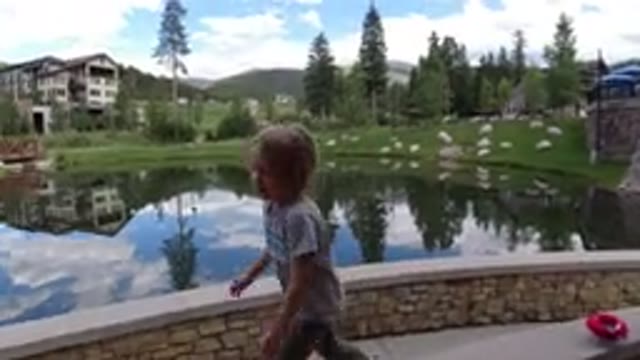 WINTER PARK COLORADO-2019: Happy Child Skipping Back And Forth On Deck Near Pond