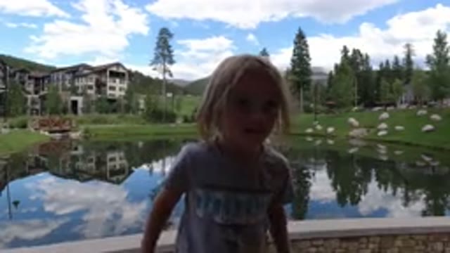 WINTER PARK COLORADO-2019: Little Girl Playing In Front Of A Lake On A Bridge