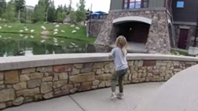WINTER PARK COLORADO-2019: Little Girl Playing On A Bridge Looking At The Lake