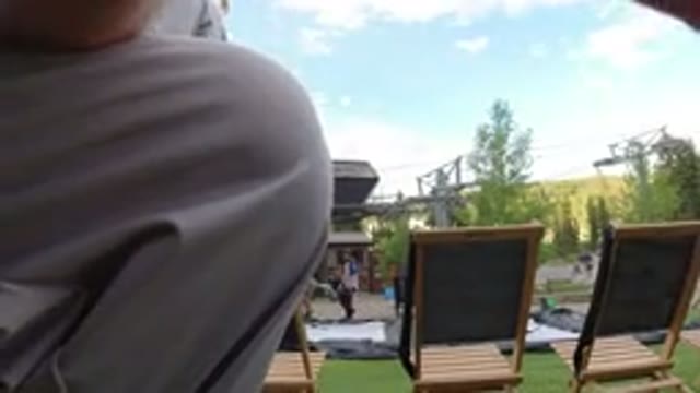 WINTER PARK COLORADO-2019: Close Up Man And Woman Stand Near Chairs On A Grass