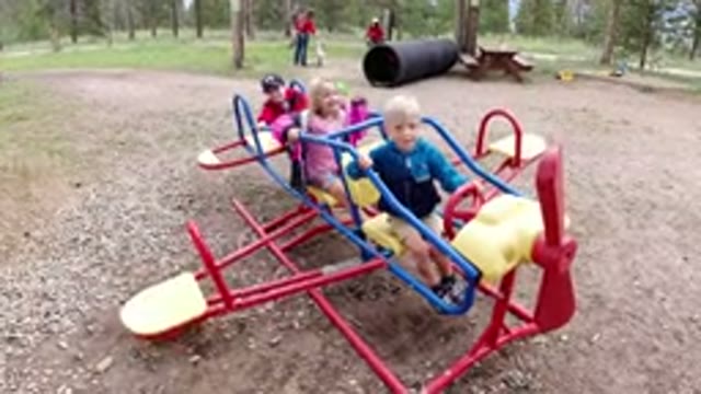 WINTER PARK COLORADO-2019: Three Children On A Playground Ride Two Boys And One Girl