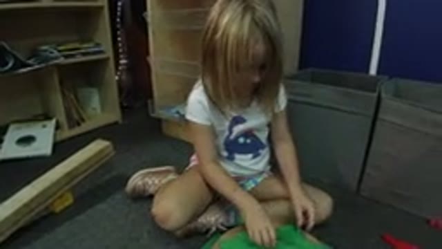 WHEAT RIDGE COLORADO-2019: Little Girl Playing On The Floor While Her Parent Watches