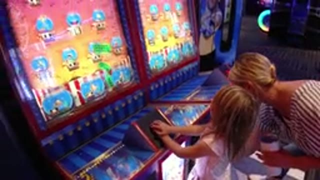 BROOMFIELD COLORADO-2019: Child Girl Playing Games Video Arcade Machine Mother