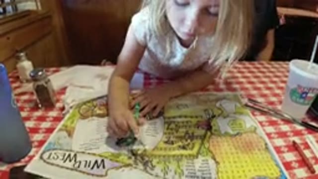 BROOMFIELD COLORADO-2019: Little Girl Colors The Road Map With Green Crayon