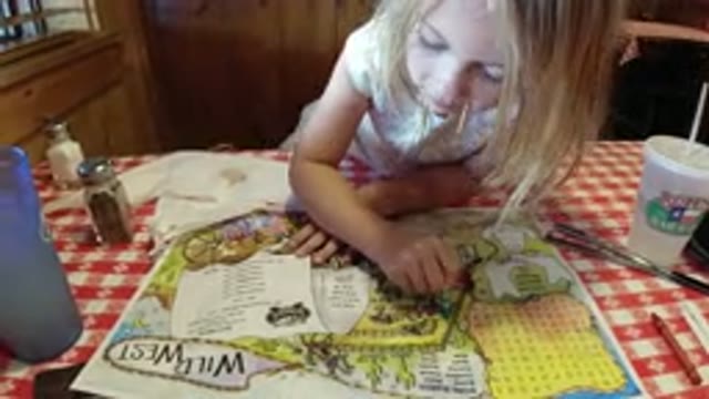 BROOMFIELD COLORADO-2019: Small Girl Reading and Playing Games with Paper