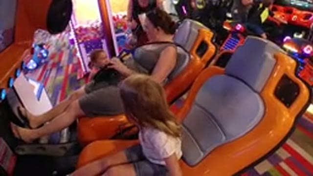 BROOMFIELD COLORADO-2019: A Woman And Young Girl Play On A Moving Arcade Machine
