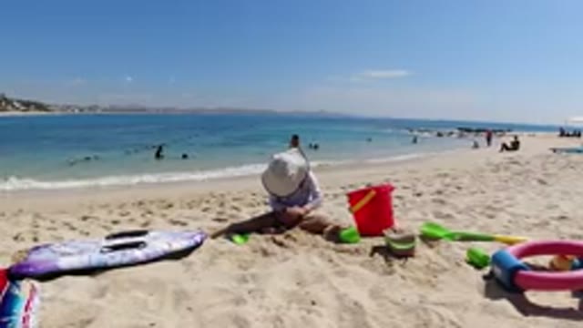 LOS CABOS MEXICO-2019: Sea Water Sand Some People Swimming Mountain Cloud Sky