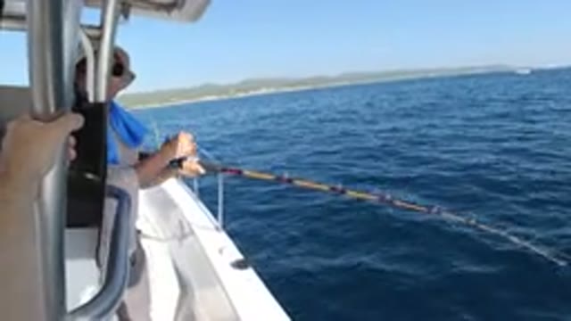 LOS CABOS MEXICO-2019: Woman Trying To Catch Fish With Stick Near Water