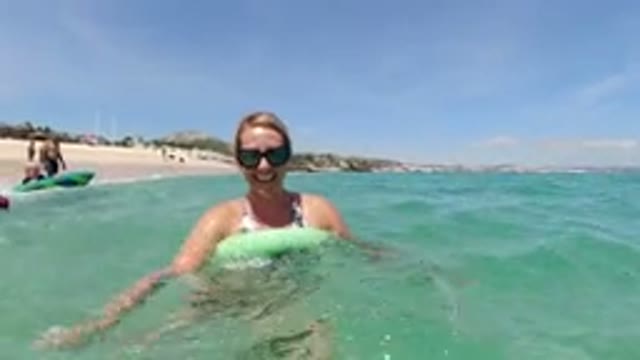 LOS CABOS MEXICO-2019: Woman Swimming Using A Green Noodle At The Beach On A