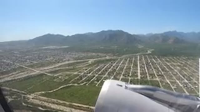 LOS CABOS MEXICO-2019: Airplane Taking Off Over Clear Skies with City and Mountain View