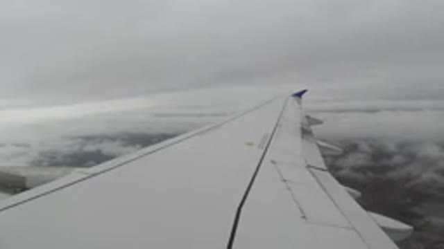 LOS CABOS MEXICO-2019: View Out Airplane Window in Flight with Clouds and Ground
