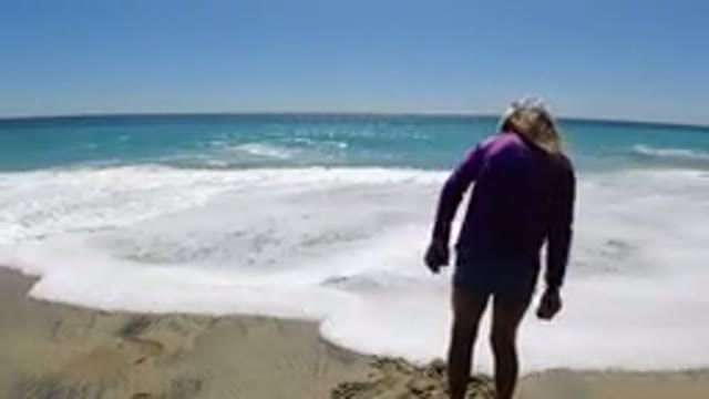 LOS CABOS MEXICO-2019: A Girl in Pink Dress and White Hat Playing on Beach