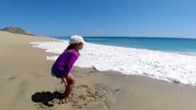 LOS CABOS MEXICO-2019: A Small Baby Playing With Water On Outdoor Beach