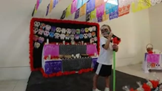 LOS CABOS MEXICO-2019: A Kid Wearing A Mask Speaking Into A Microphone Stand