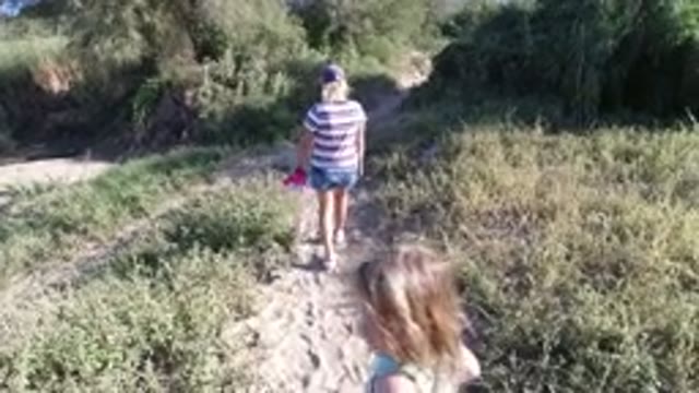 LOS CABOS MEXICO-2019: Two People Walking Down A Sidewalk Dirt Road Pathway In