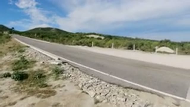 LOS CABOS MEXICO-2019: An Empty Straight Road Near the Beautiful Small Green Hills