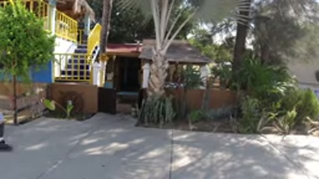LOS CABOS MEXICO-2019: A Man Walking The Sidewalk Looks Into A Balcony Where