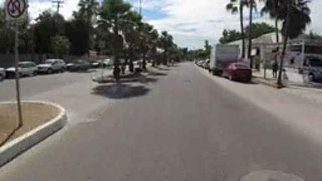 LOS CABOS MEXICO-2019: A View Traveling Down A Paved Street With A Median And