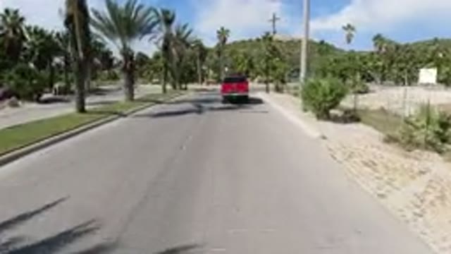 LOS CABOS MEXICO-2019: Chasing A Red Pickup Vehicle Through A Road In A Dry Area
