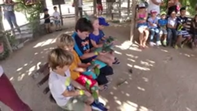 LOS CABOS MEXICO-2019: Kids Sitting On Bench Surrounded By Sand Reaching Their Arms
