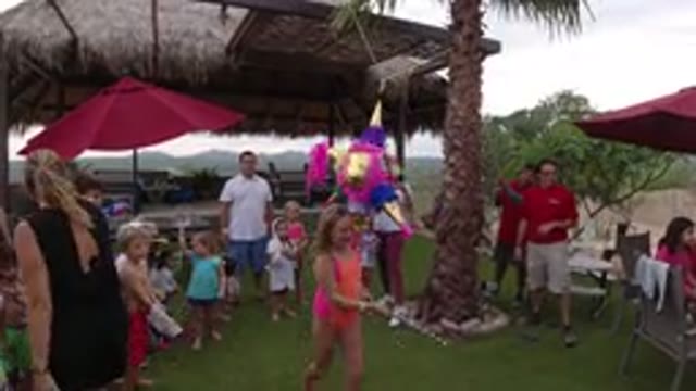 LOS CABOS MEXICO-2019: Little Girl Hitting A Pinata As Her Family Watches