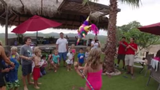LOS CABOS MEXICO-2019: Little Girl Hits Pinata at Beach Birthday Party