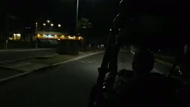 LOS CABOS MEXICO-2019: Road Cam Of A Man Driving Past Shops During The Night