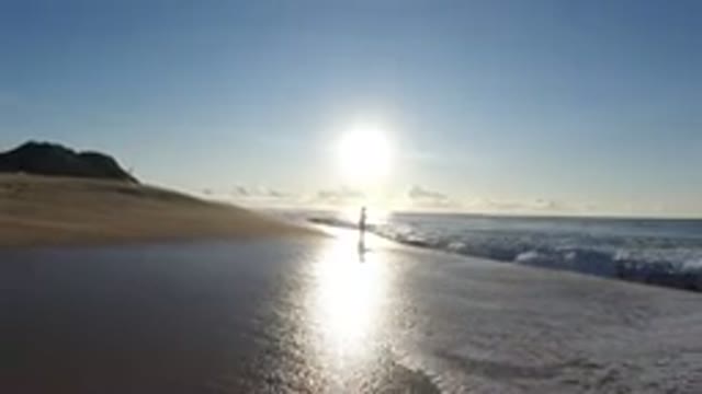 LOS CABOS MEXICO-2019: Person Standing On A Beach In The Surf Alone As The Sun