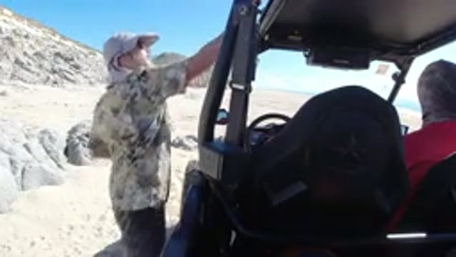 LOS CABOS MEXICO-2019: Man Looking At The Wrangler In The Beach While Friend