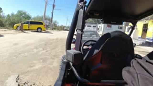 LOS CABOS MEXICO-2019: Wrangler Standing In Dusty Area Near Black Truck With Passersby