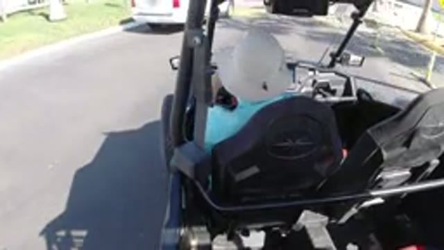 LOS CABOS MEXICO-2019: Man In Hat Driving Golf Cart Over Speed Bump