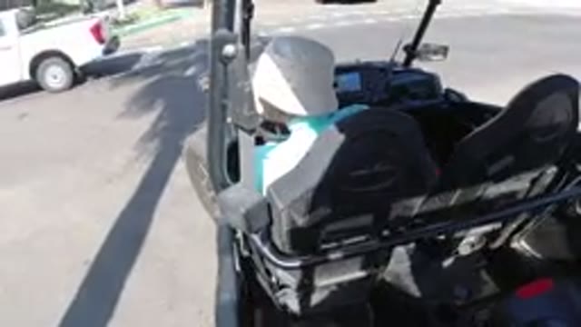 LOS CABOS MEXICO-2019: Man In Hat Driving Golf Cart On Paved Road Behind A