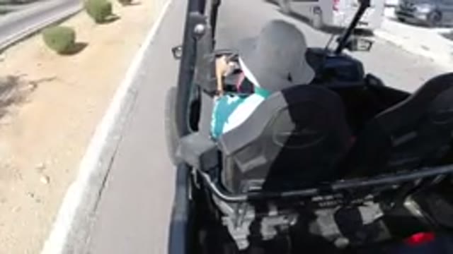 LOS CABOS MEXICO-2019: Man Drives Buggy Down A Dusty Street With Hat On
