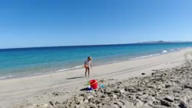 LOS CABOS MEXICO-2019: Child On The Beach Playing With Sea Water Bucket Shovel