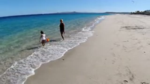 LOS CABOS MEXICO-2019: Kid Playing in Small Waves Hitting Sea Shore