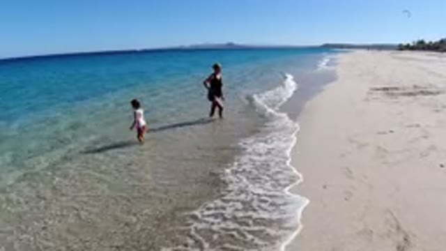 LOS CABOS MEXICO-2019: An Adult And A Kid Playing On The Beach In The Water