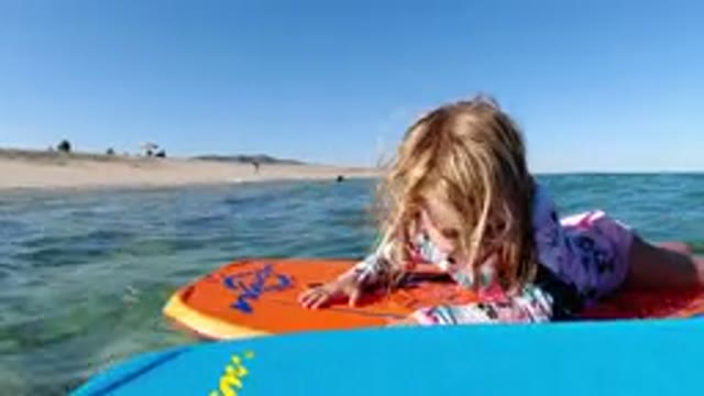 LOS CABOS MEXICO-2019: A Kid Floating On A Board In The Ocean On A Sunny Day