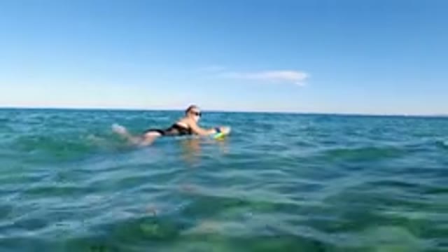 LOS CABOS MEXICO-2019: Woman On A Surfboard In A Black Bathing Suit In The Sea