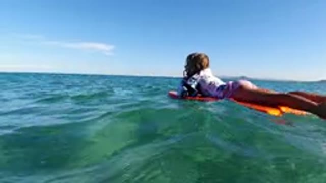 LOS CABOS MEXICO-2019: Girl Lying On Surfboard Sailing On Waves